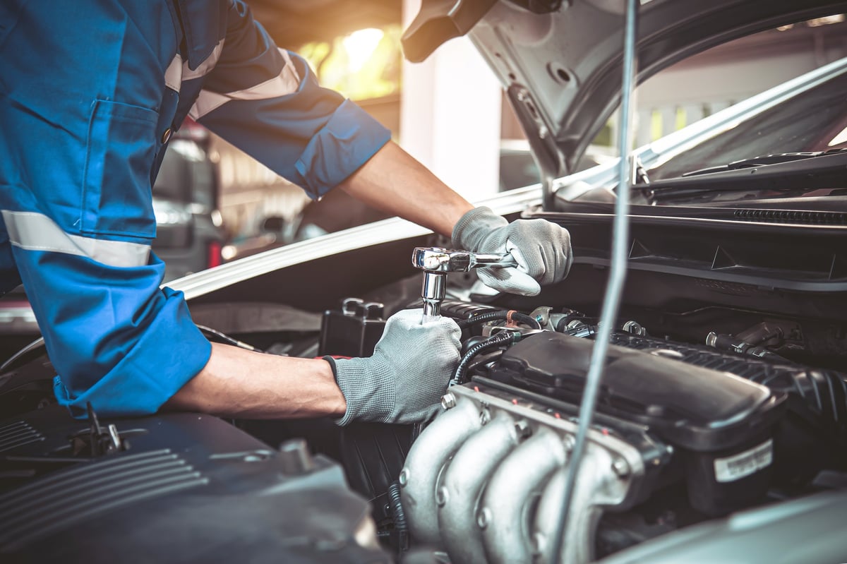 Close-up of a technician using a wrench to repair and service a car engine