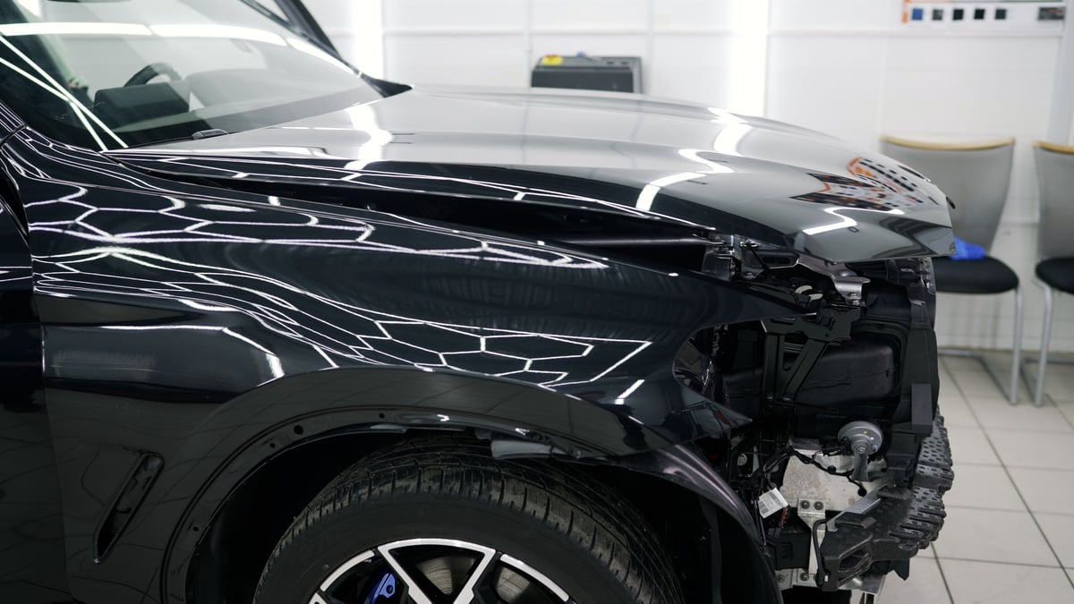 Damaged car being carefully restored to its original condition by skilled mechanics in a specialized repair workshop